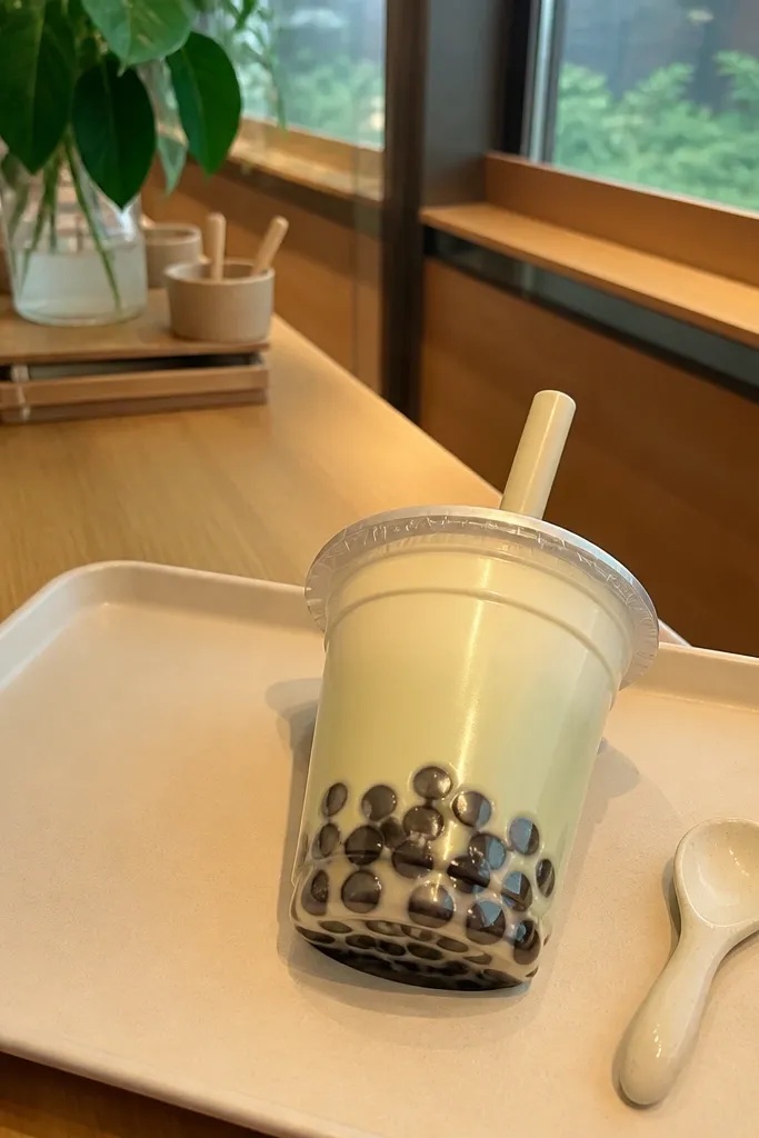 Clear-style boba tea cup paper squishy with brown pearls and a pastel straw