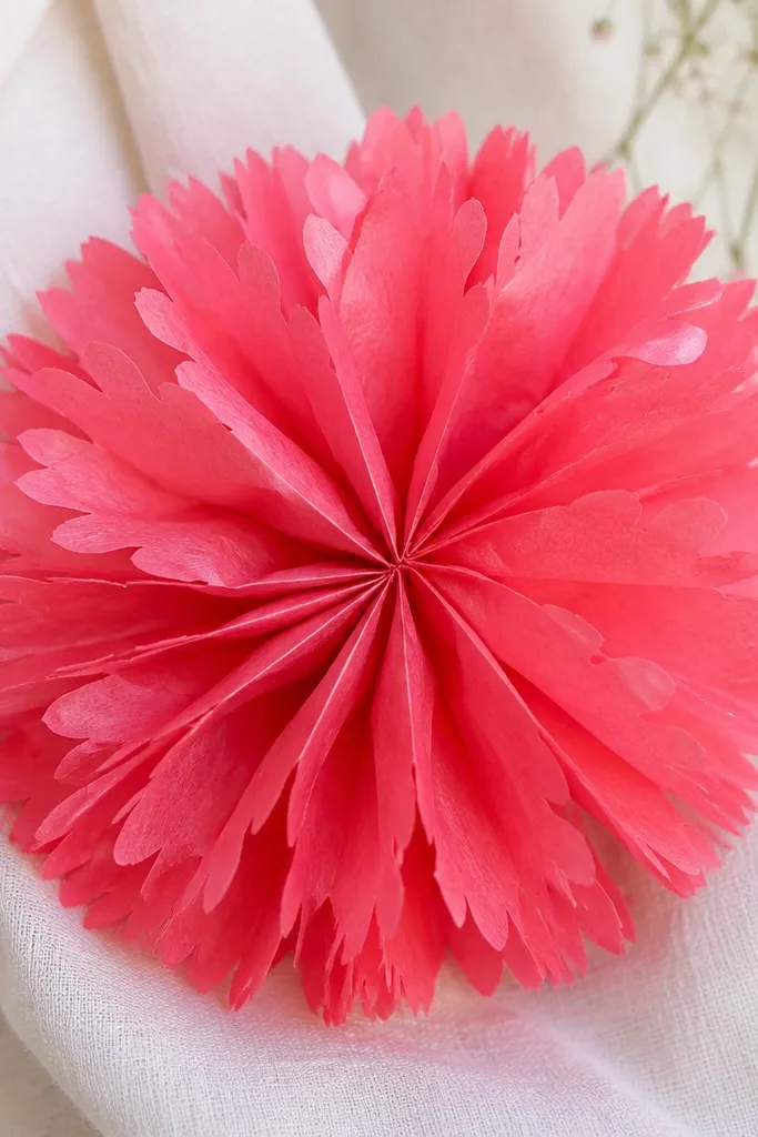 A bright tissue flower with fringe petals that look like little butterfly wings. The fringe is crisp and the center is tightly cinched.