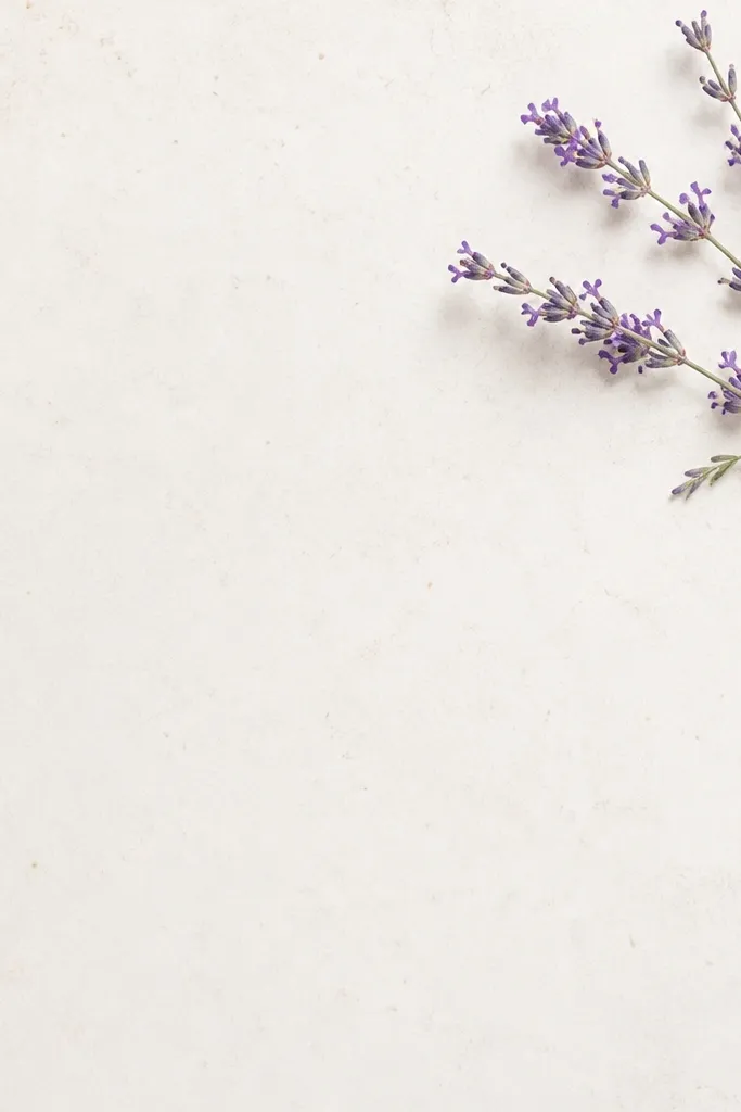 A frame with a lavender sprig placed in the top-right corner. Small purple buds and thin stems appear delicate, with a few tiny leaves added along the stem. Background is warm white with subtle speckling.
