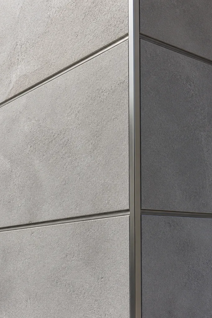 Light cement board facade with thin metal edging at panel corners