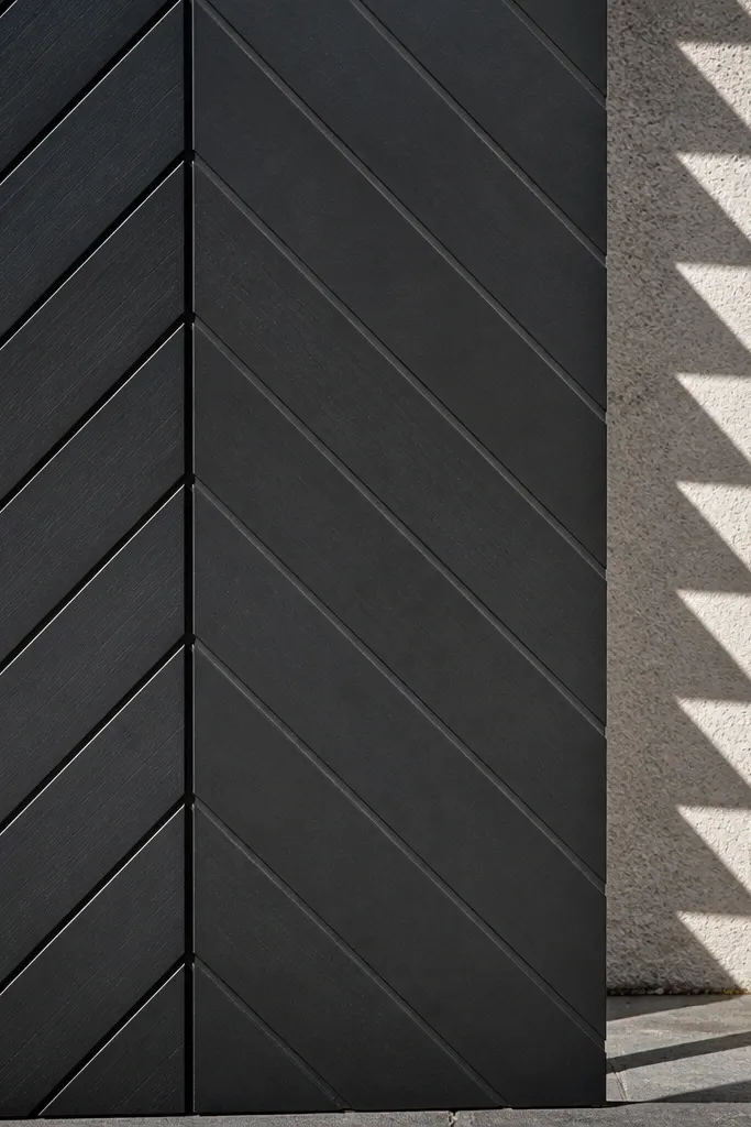 Black window grill with chevron V pattern and a vertical divider