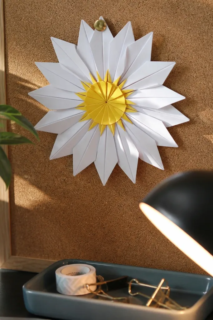 A daisy with white petals and a starburst yellow center made of tabs