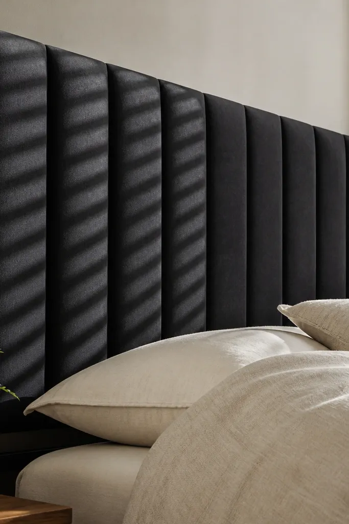 Matte black fabric headboard with vertical channel lines across the surface