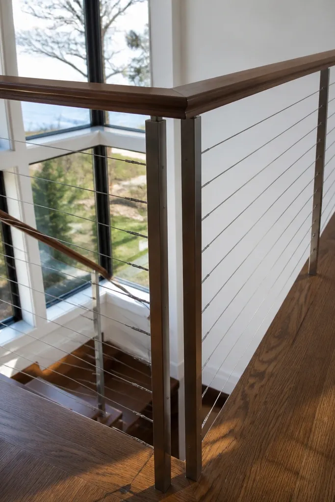 Stainless cable lines with a smooth wood handrail and black posts