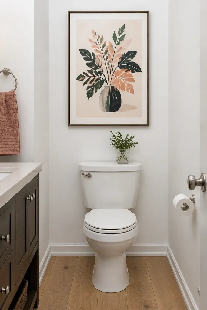 Framed botanical-style print above a toilet in a small bathroom
