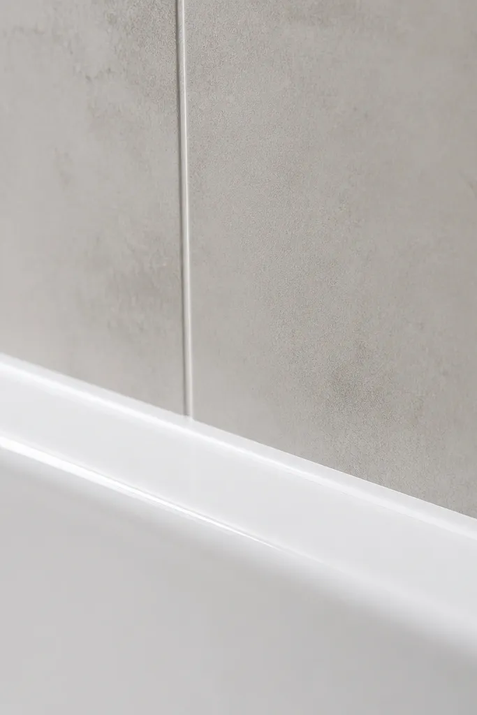 Tub edge with a smooth new caulk line between tub and wall