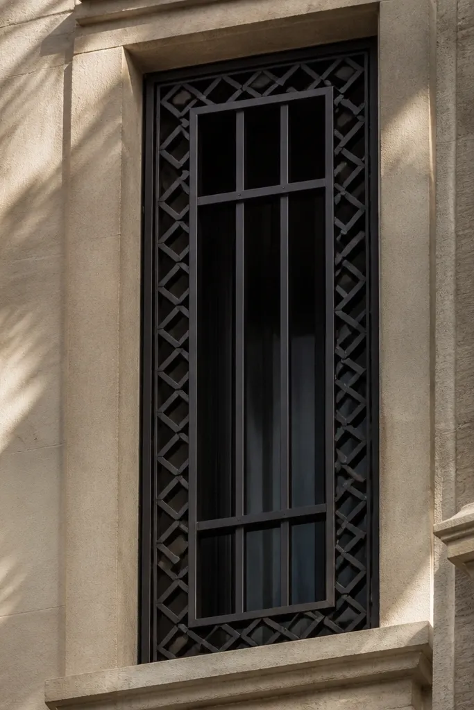 Black window grill with diamond-shaped border lines around a simple interior