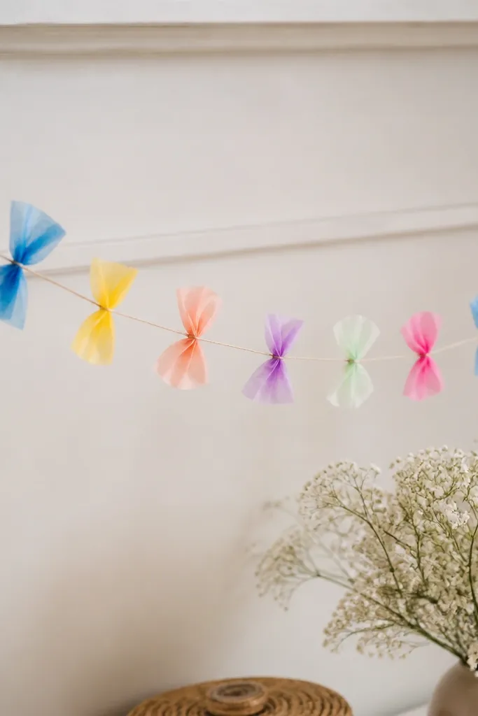 A garland of small butterfly flowerettes in mixed colors, each with two tissue wings and a tiny center knot on a string.