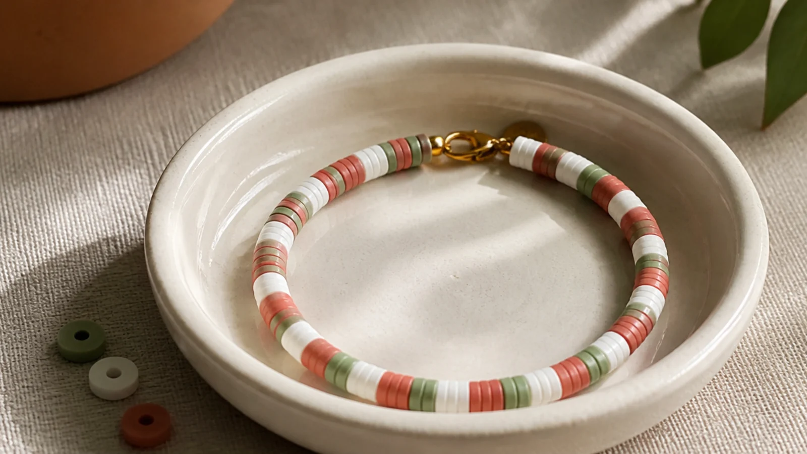 A clay bead bracelet repeating red, white, and a second color in a candy-stripe sequence.