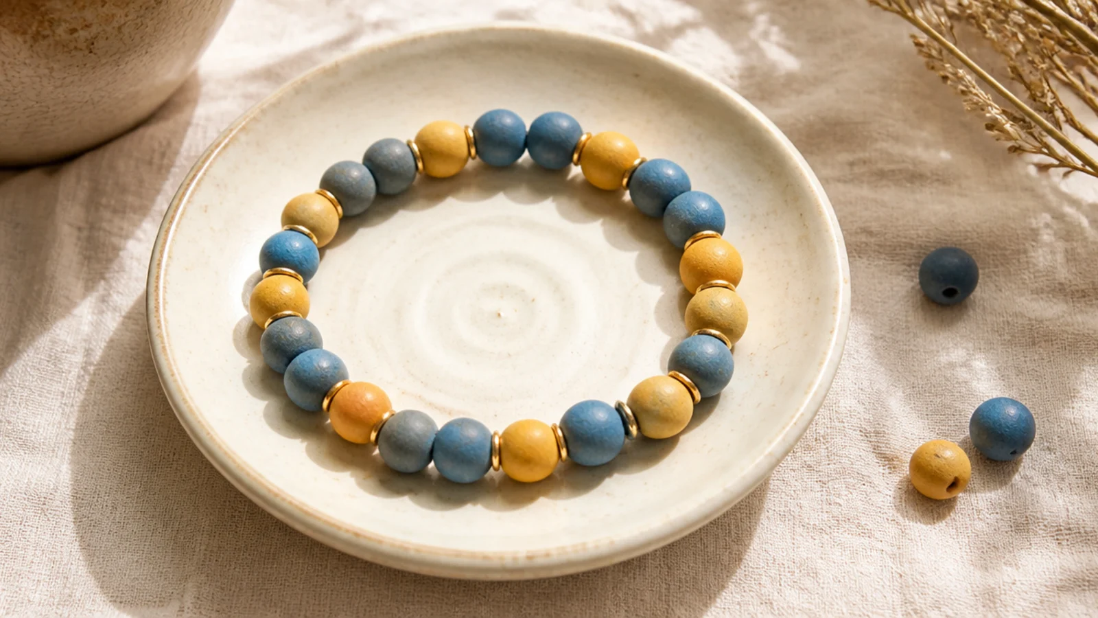 A clay bead bracelet alternating pairs of complementary colors, dusty blue and warm mustard.