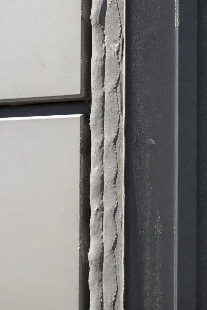 Thick messy caulk blobs at panel joints and window trim