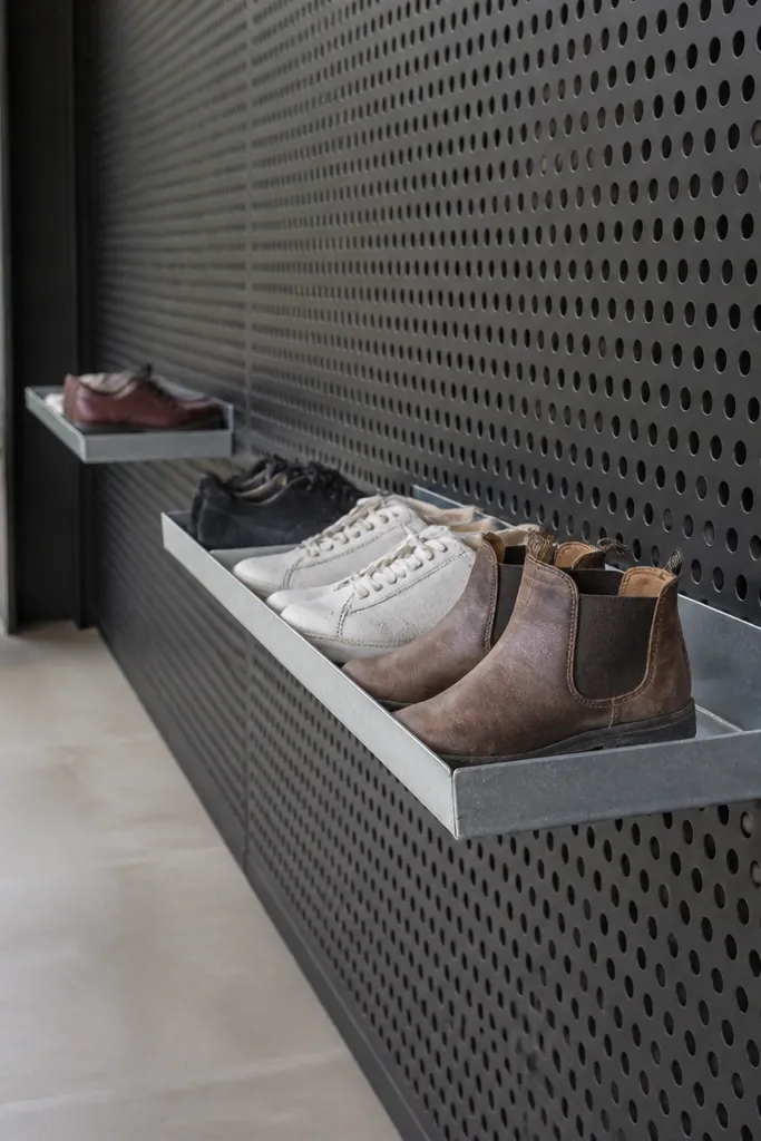 Perforated metal panel on a porch with small removable trays holding pairs
