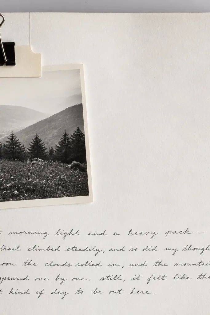 A page with a white background and a small black binder clip holding a photo at the top left. The binder clip is clipped onto a cardstock tab, with the photo partially visible beneath. Handwritten captions run along the bottom.