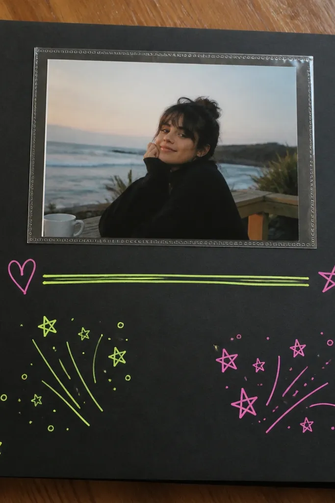A black cardstock page with neon green and pink handwriting. A single photo is placed in a clear pocket at the top. Small star stickers dot the corners. A neon underlined caption runs across the middle.