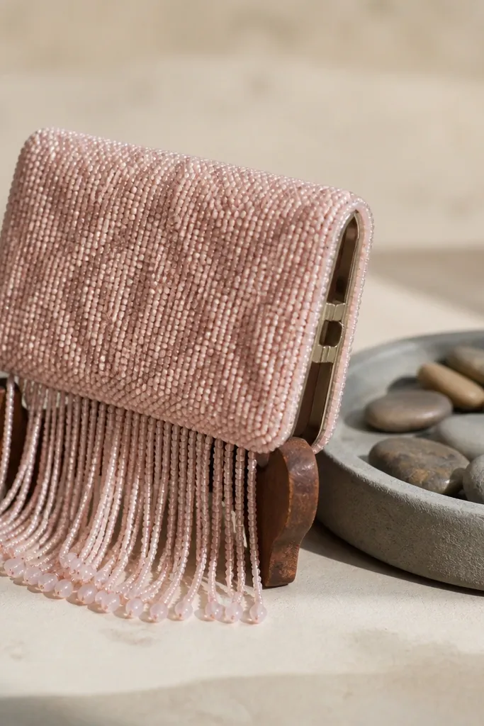 Rose quartz colored beadwork on a pink Altoids wallet with short fringe at the bottom