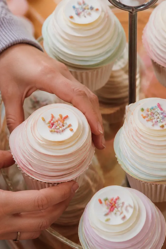 Paper cupcake with rainbow sprinkles and a big fluffy icing swirl
