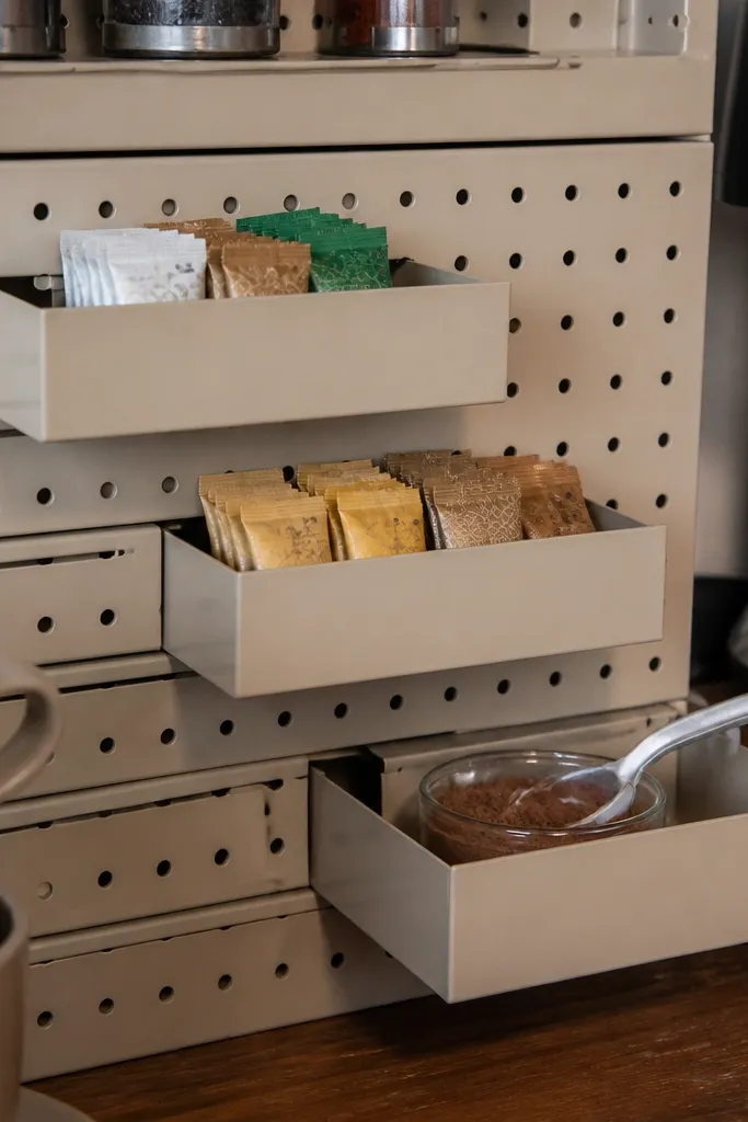 Pegboard coffee wall with small sliding drawers for cinnamon and sweeteners