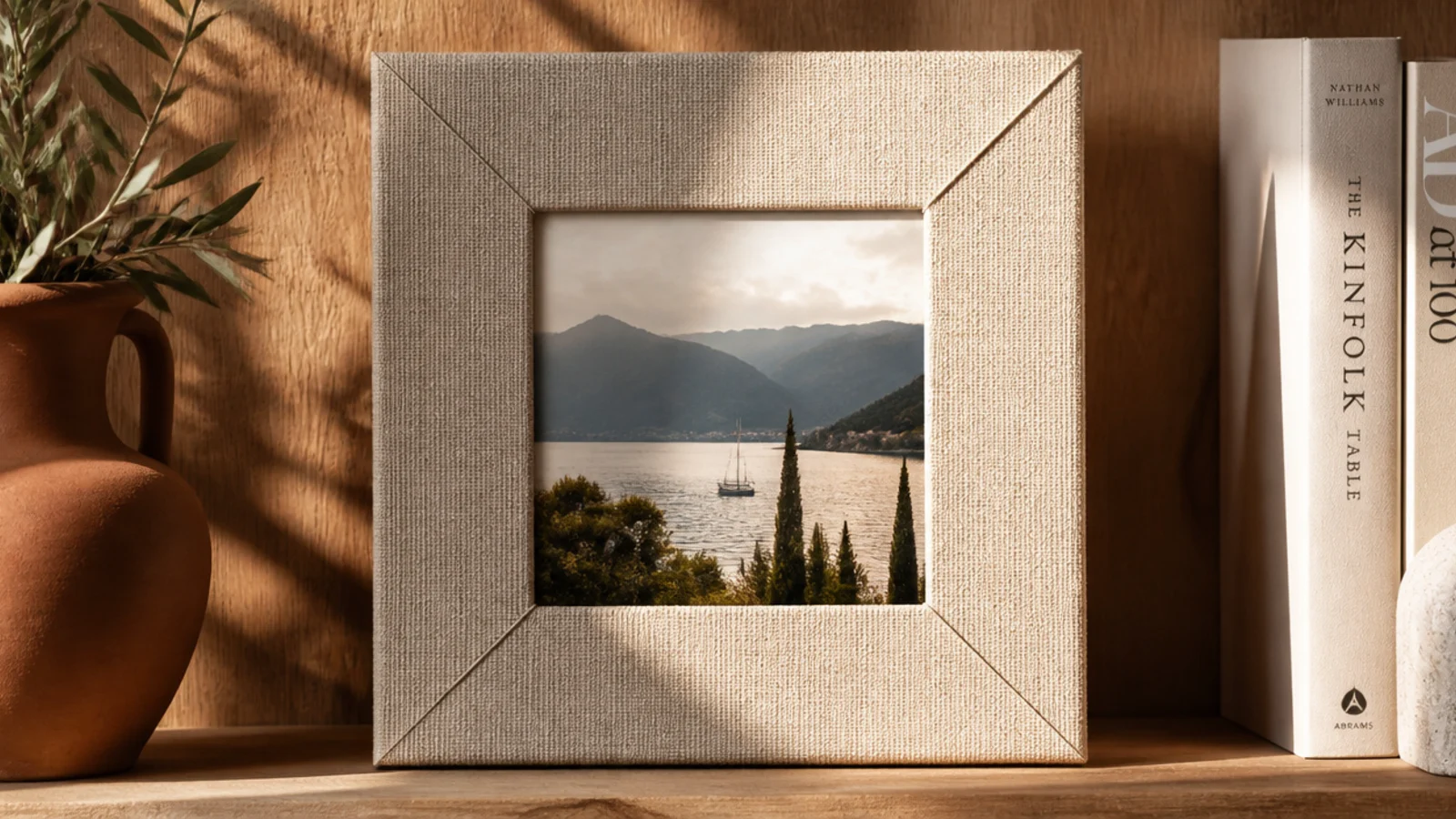 A photo frame wrapped in natural linen fabric with neat folded corners around a central opening.
