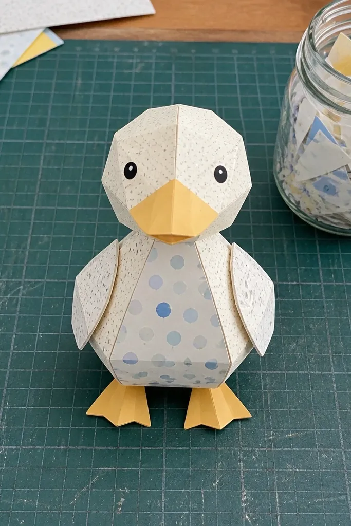 Yellow paper duck decorated with small colorful scrap speckles on wings and body