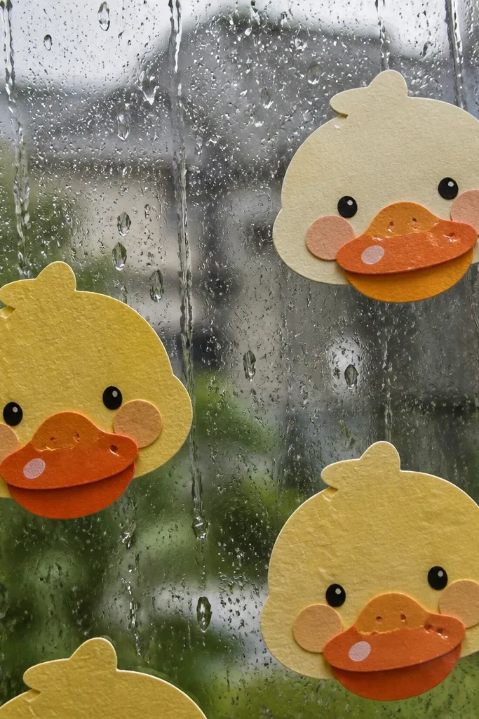 Duck stickers on a window with raindrop dots and a glossy tape highlight