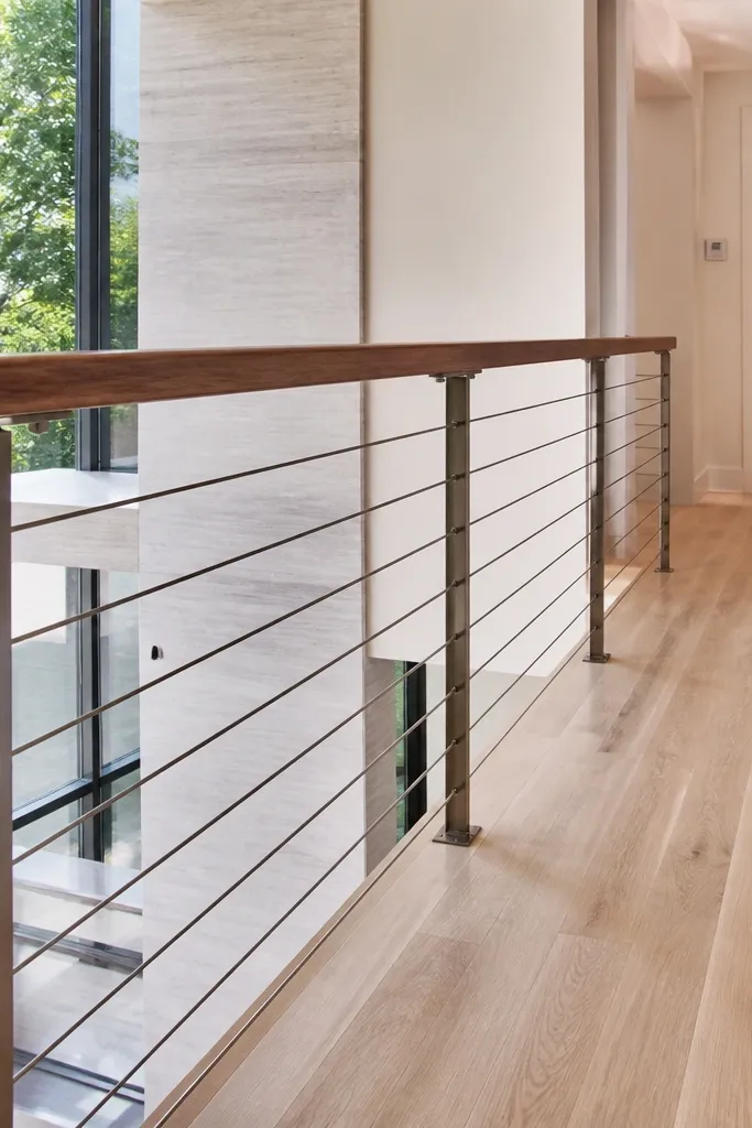 Two horizontal cable lines with a dark walnut handrail over a stair