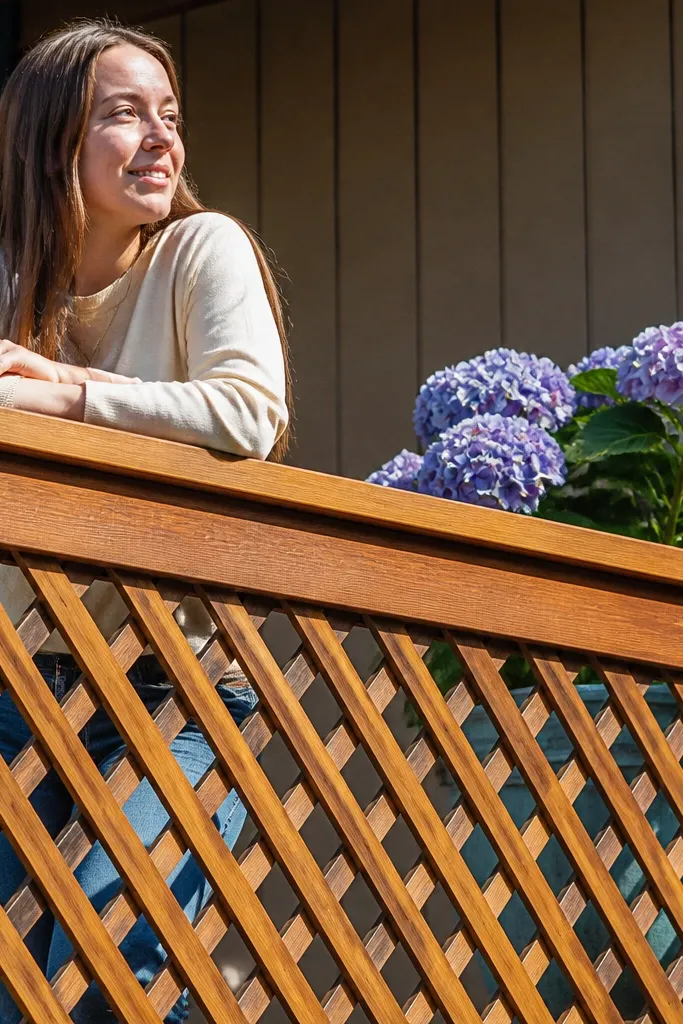 Diagonal wood lattice infill balcony railing with a wide top cap