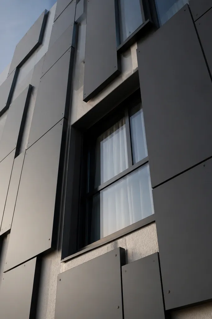 Matte black metal panel rectangles on a light wall with modern boxy window frames