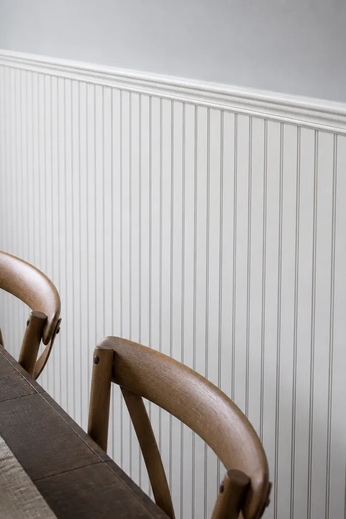 White beadboard wainscoting with a framed border above and soft taupe walls