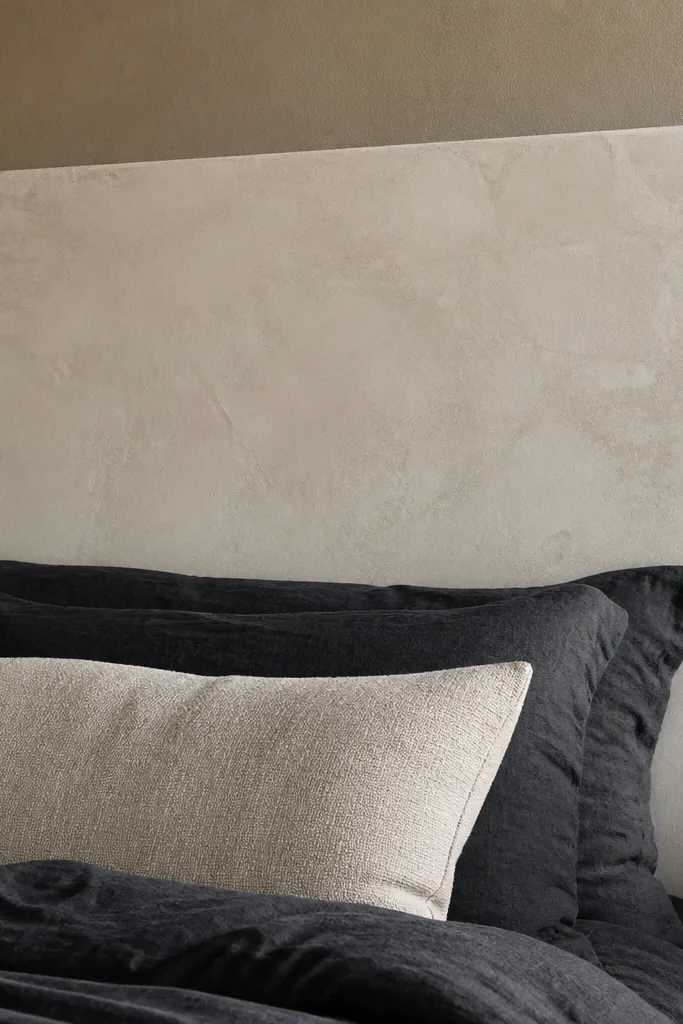 Light gray cement board headboard with subtle mottled limewash texture