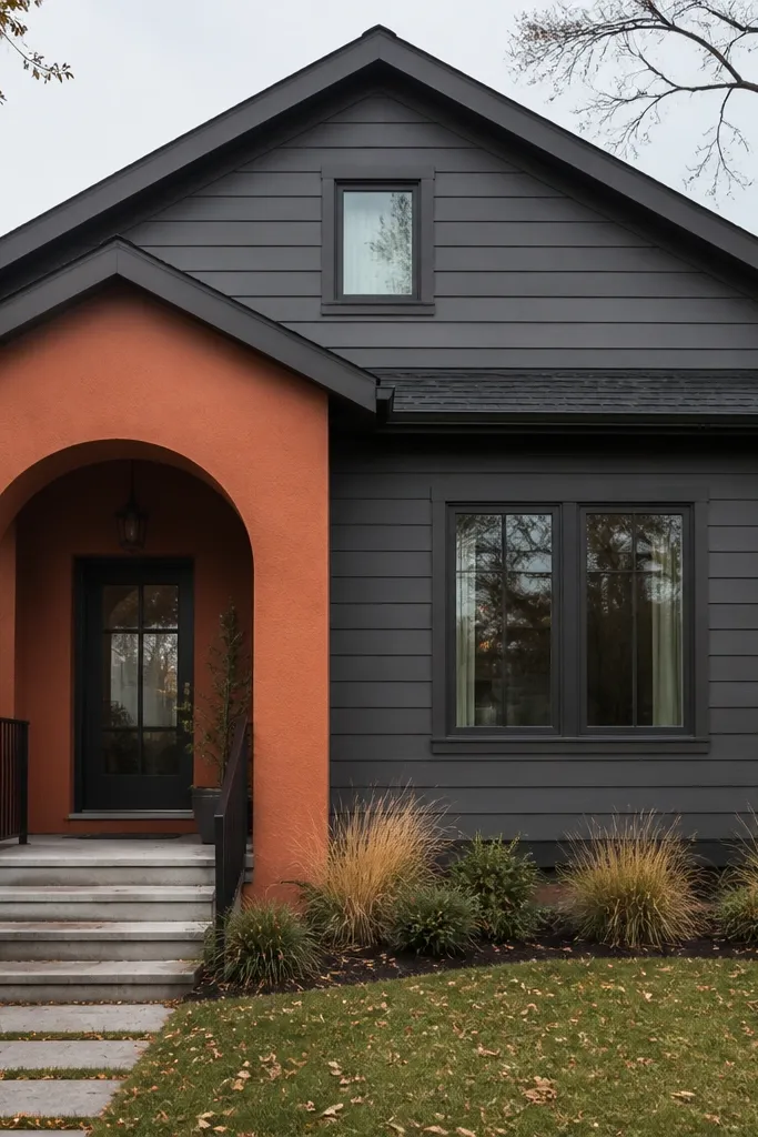 Slate gray facade with a muted terracotta panel around the entry