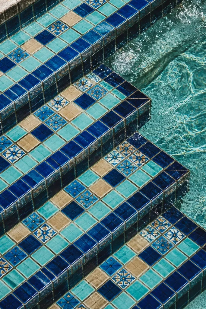 Tiled steps leading toward ocean water with repeating blue patterns