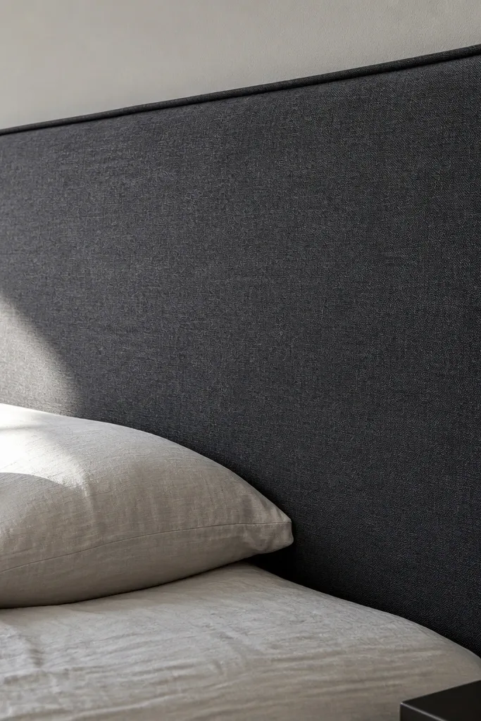 Tall upholstered headboard with crisp piping and straight fabric lines