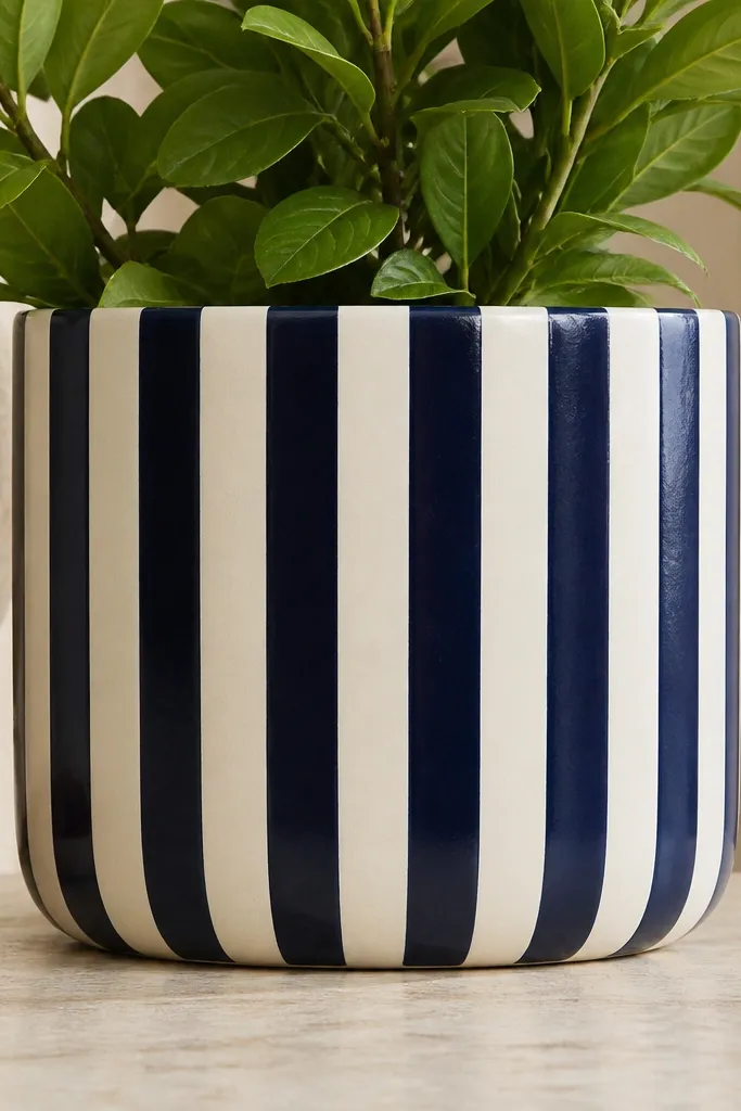A pot with alternating navy and cream vertical stripes; stripes are perfectly straight and evenly spaced around the entire pot.