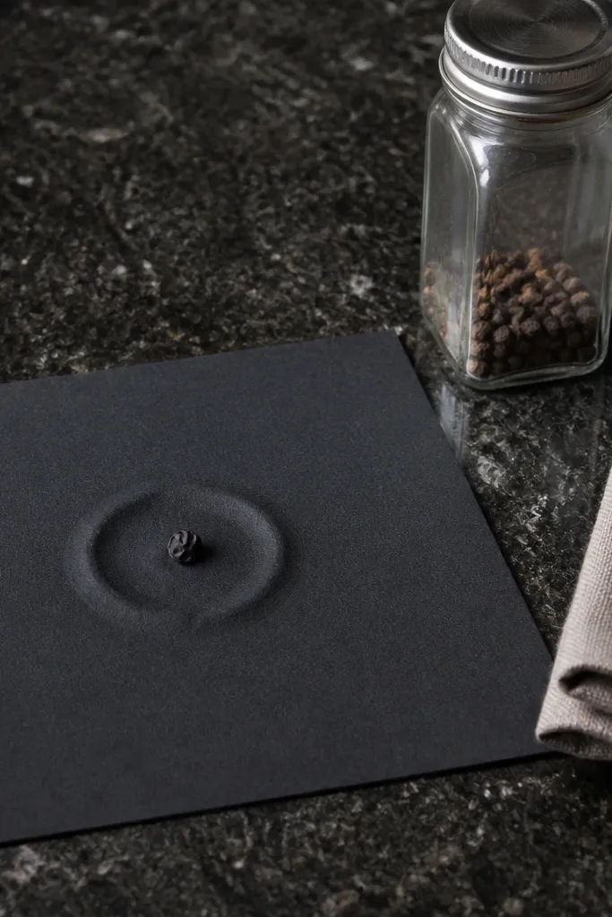 Small black peppercorn dot with a thin depth ring and light highlight