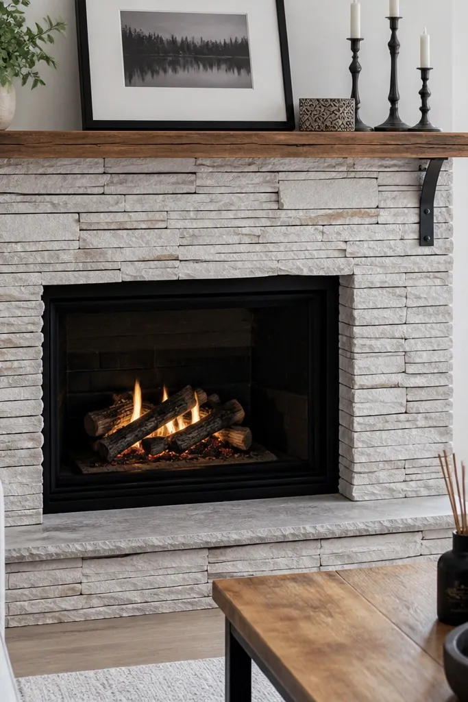 Whitewashed stacked stone fireplace with dark grout lines and a black mantel