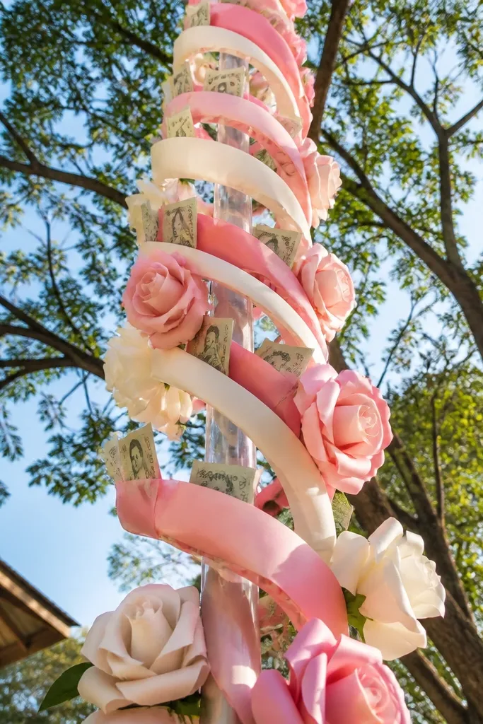 Paper roses arranged in a spiral with twisted ribbon stems and folded bills tucked along the spiral