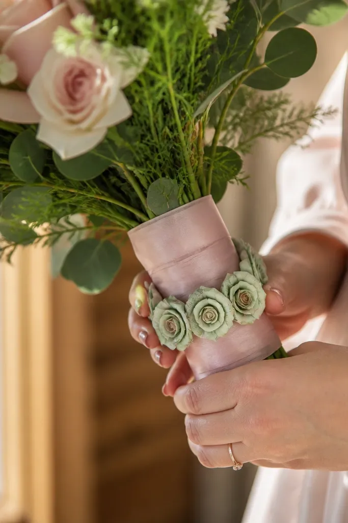 Mini money rose garland wrapped around bouquet stems with pastel ribbon