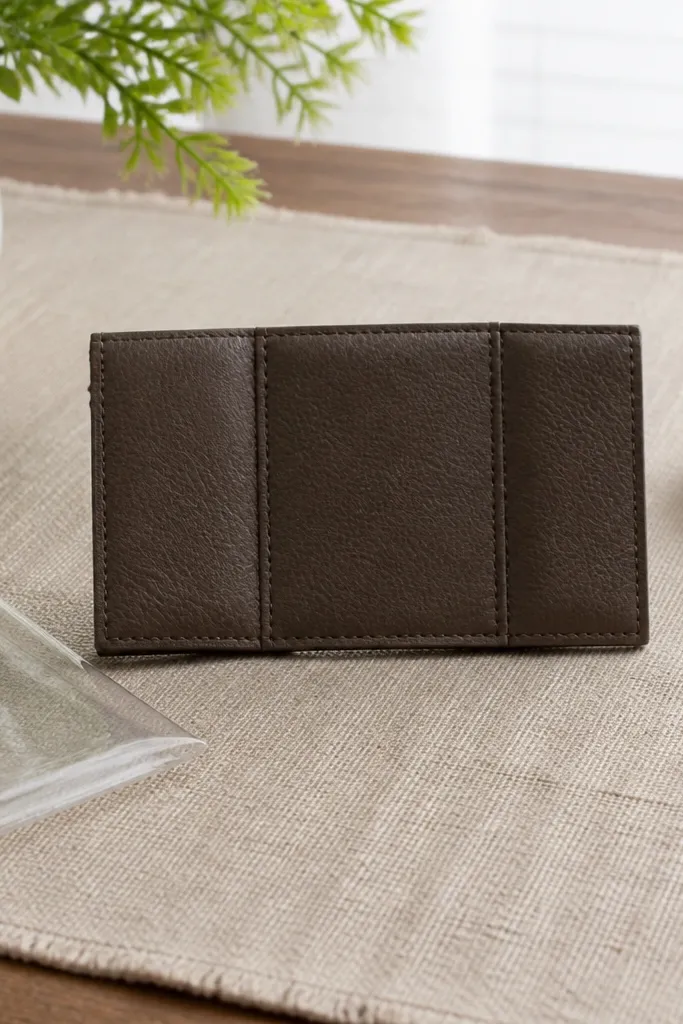 A $15 bill folded into a neat three-panel wallet with a front flap