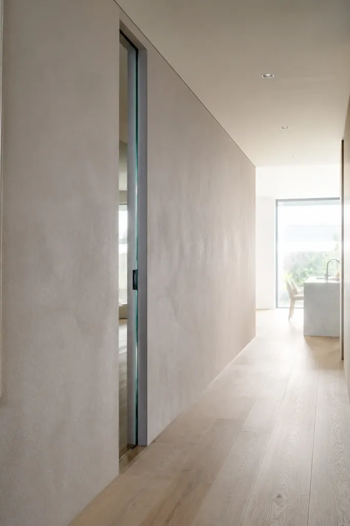 Glass sliding door disappearing into a wall pocket with minimal visible track