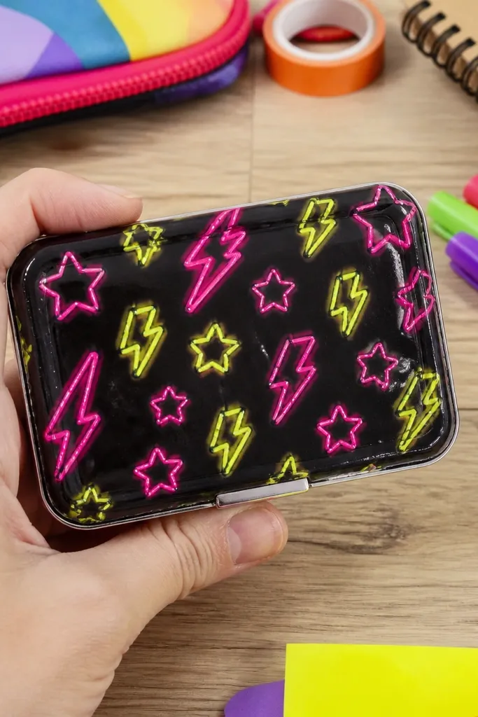 Neon outline vinyl shapes on an Altoids wallet with a clear sealed top