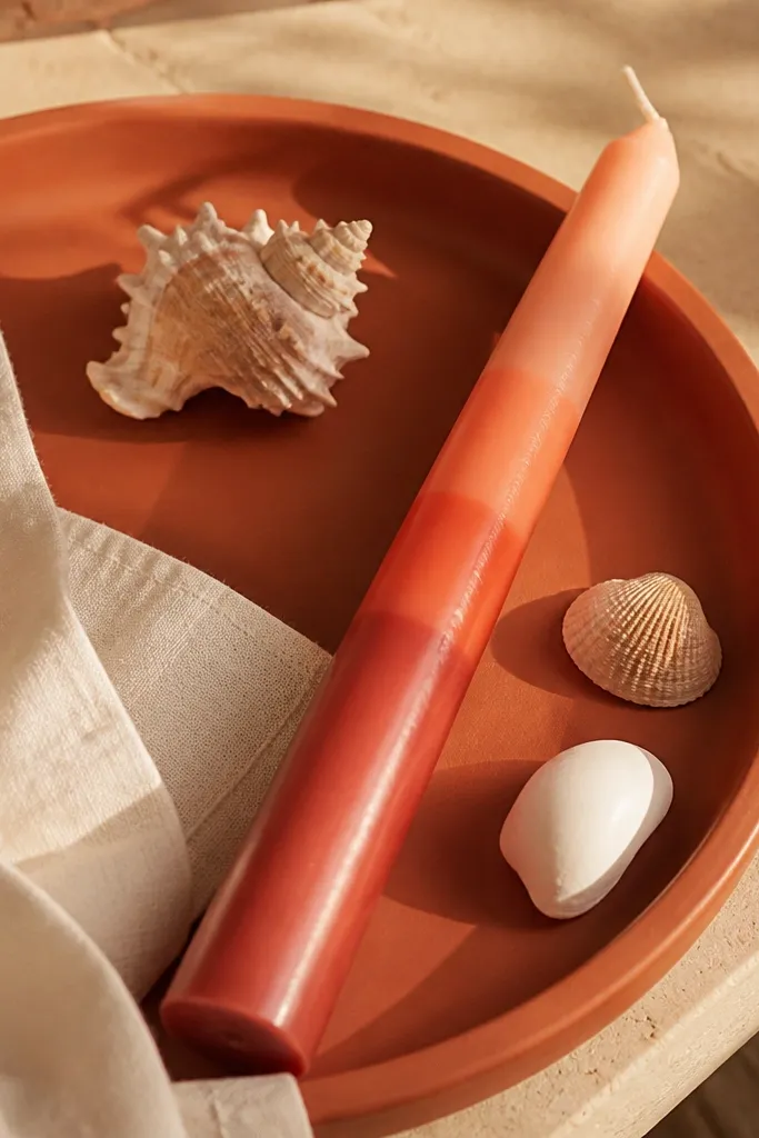 Candle with layered bands going from peach to coral like a sunset