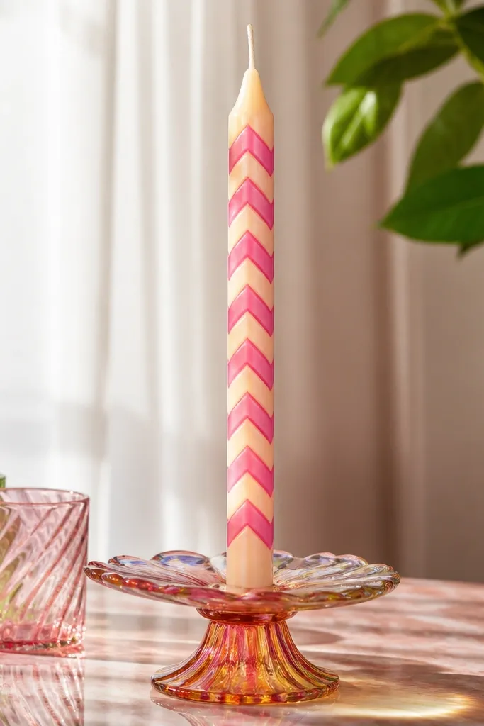 Ivory candle with colorful chevron stripes and glossy shine at stripe edges