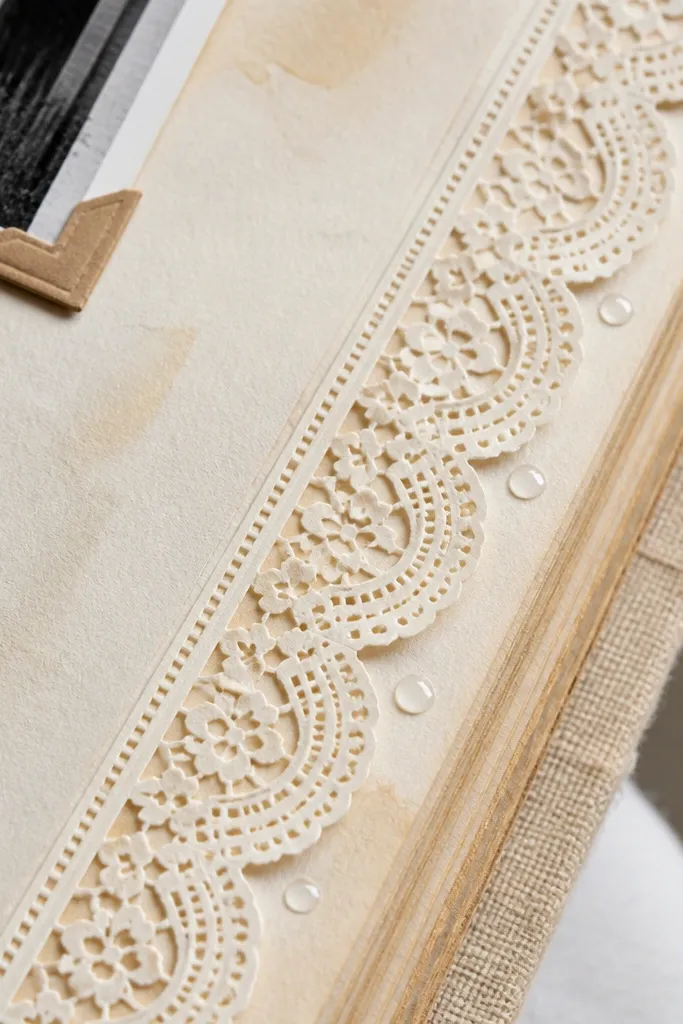 A cream page with a lace-like edge strip and faint vintage speckles.