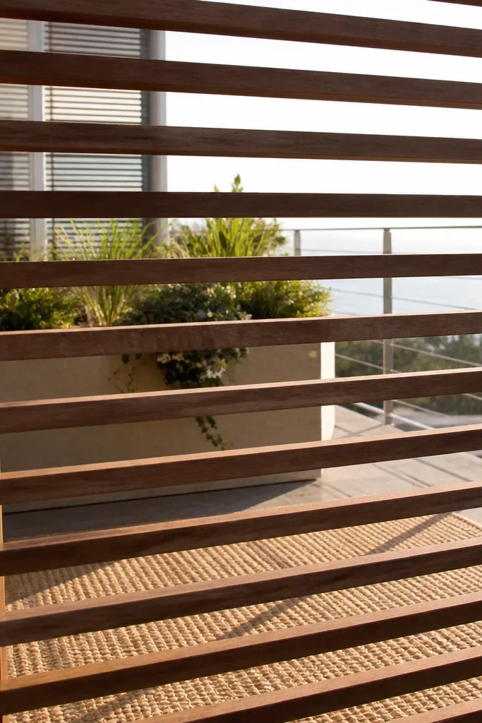 Horizontal wooden slats with even spacing mounted across a balcony railing