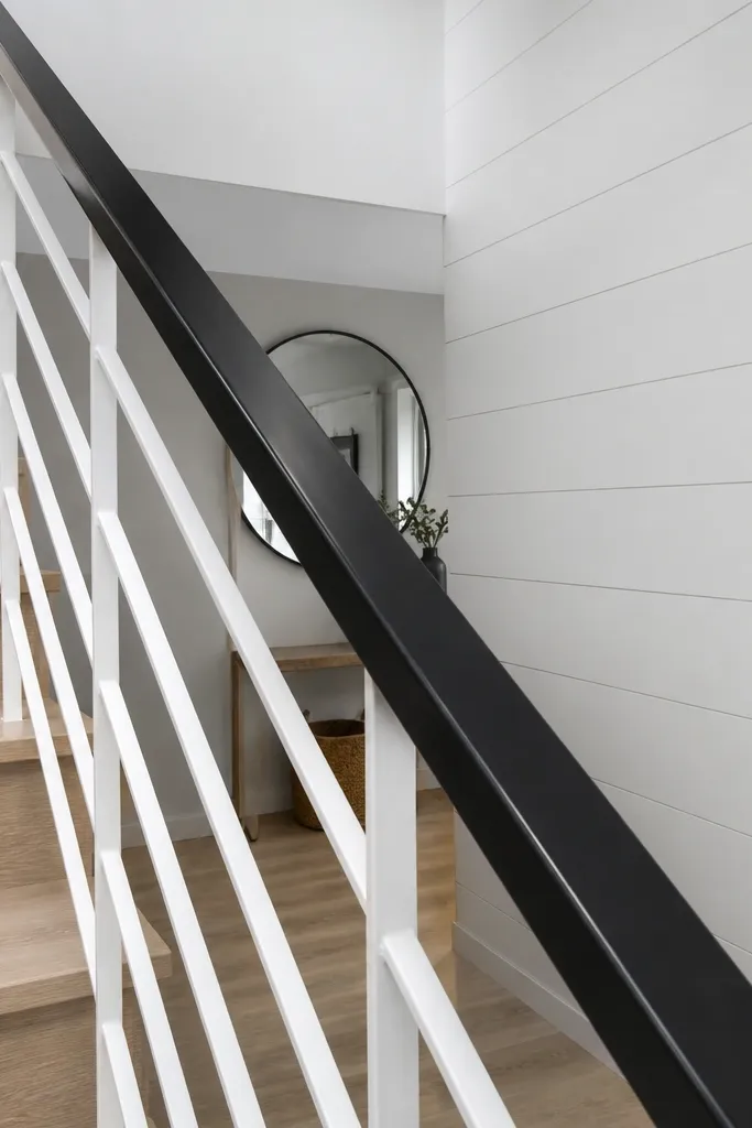 Dark handrail with white metal balusters on indoor stairs