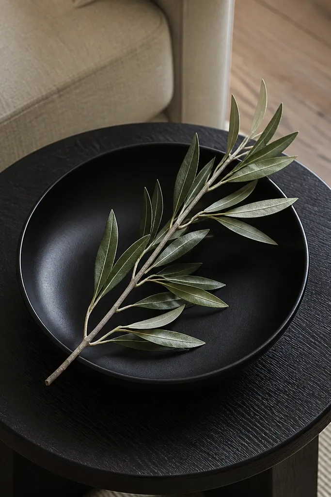 White ceramic bowl centered with a faux olive branch arching upward