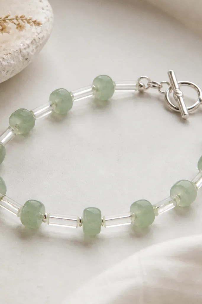 A sea-glass green bracelet: translucent green clay beads separated by clear tube beads, finished with a silver toggle clasp.