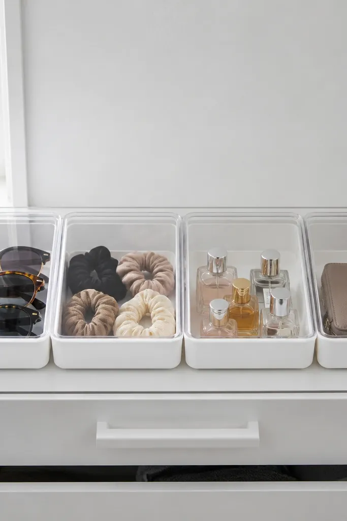 Clear-lidded bins stacked on a closet shelf with neatly aligned labels