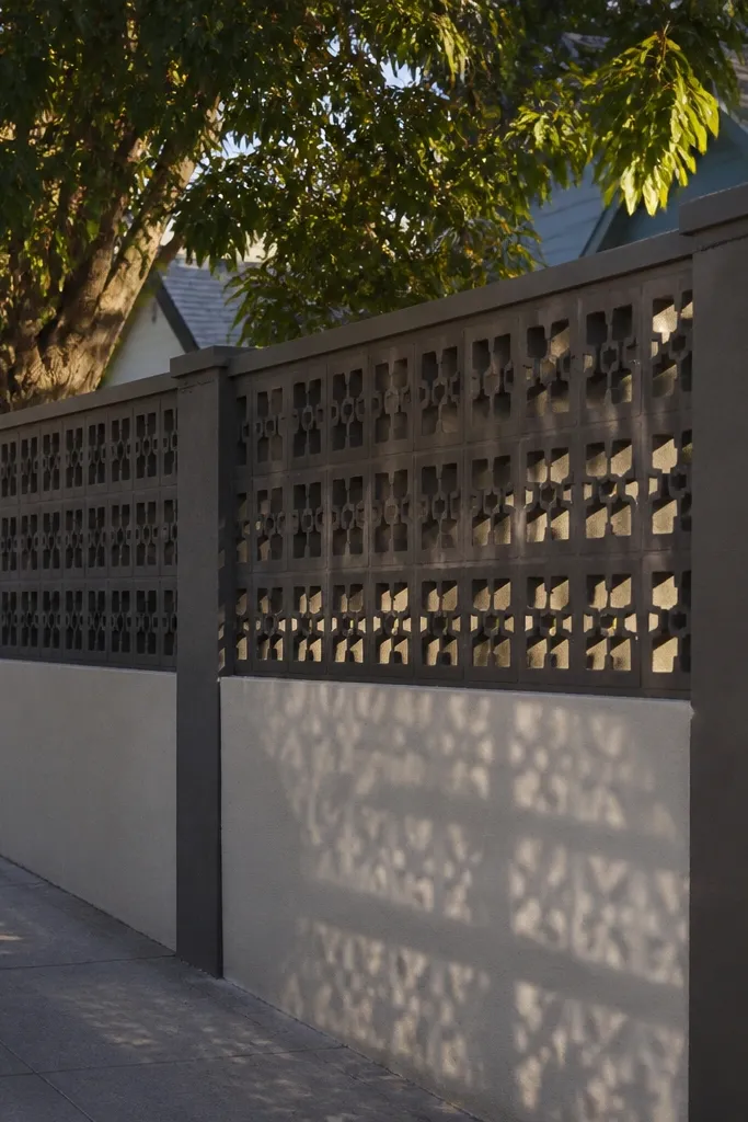 Solid gray wall base with a perforated block pattern on top and a clean coping line.