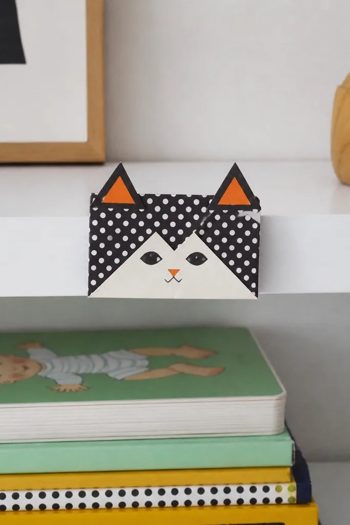 Polka dot folded cat face with raised ears and a small paw flap